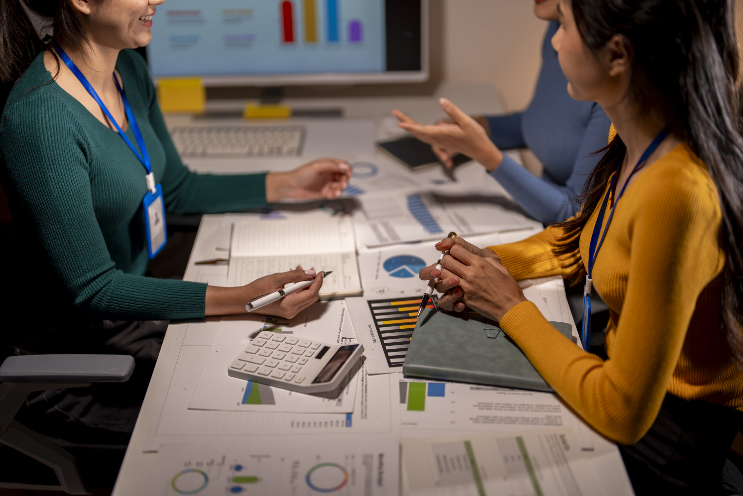 Professionals discussing data charts and KPIs as part of a collaborative sales performance management session.
